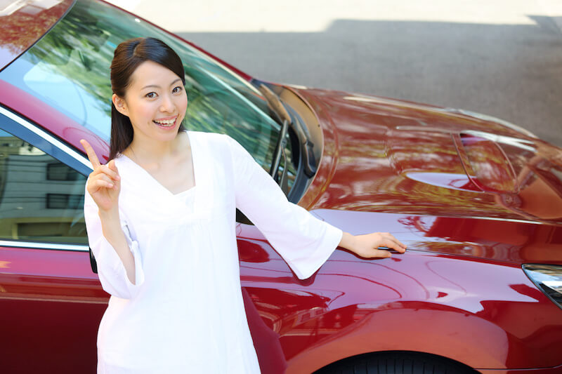 車の前で笑顔の女性
