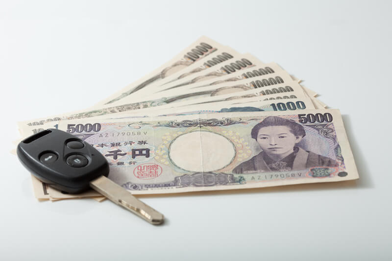 車の鍵と日本のお札の写真