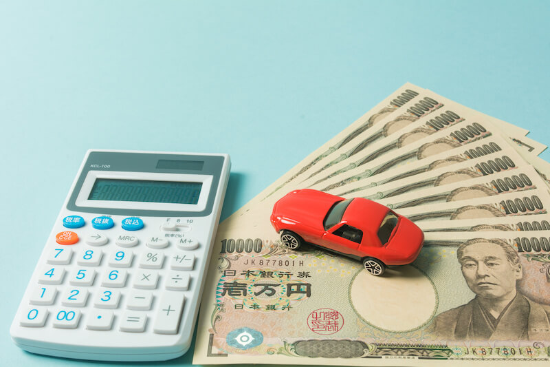電卓と日本円と赤い車