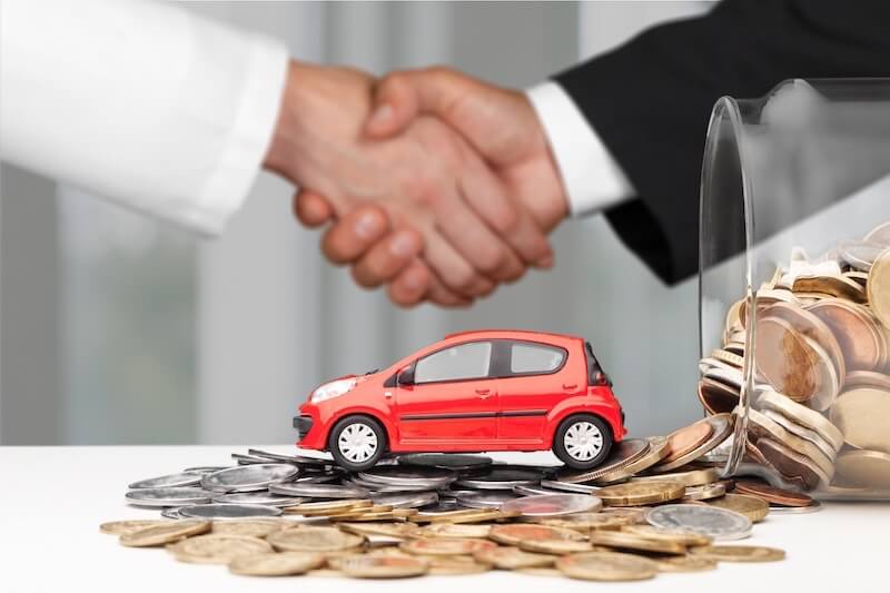 握手する人たちとお金と車
