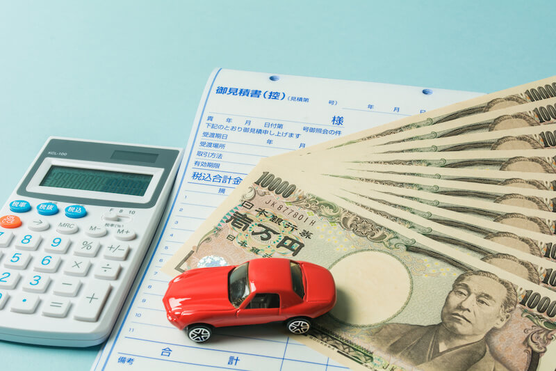 1万円札数枚と赤い車