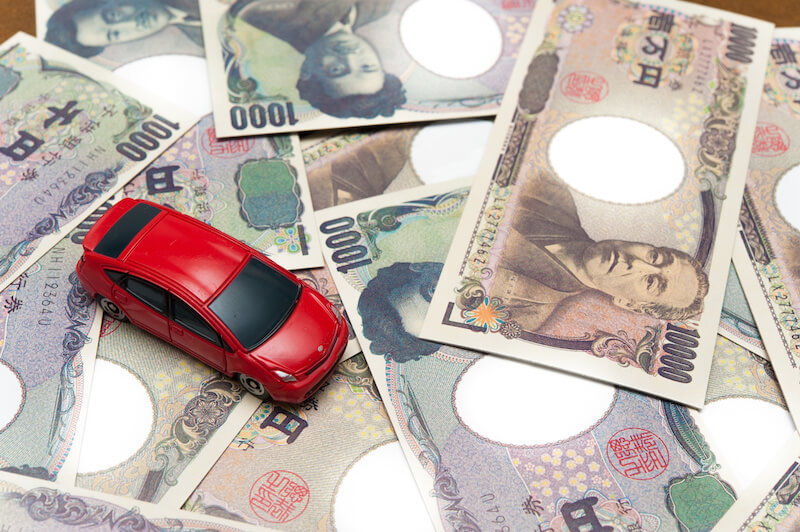 お札と赤いミニカー