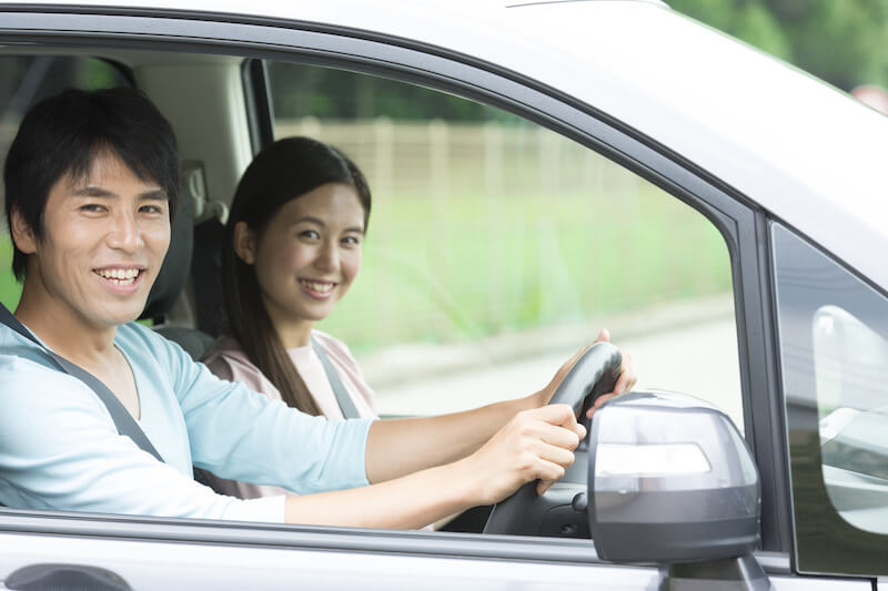 車に乗って笑顔の男女
